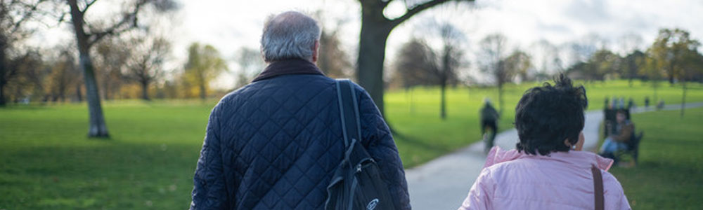 Two adults walking through a park